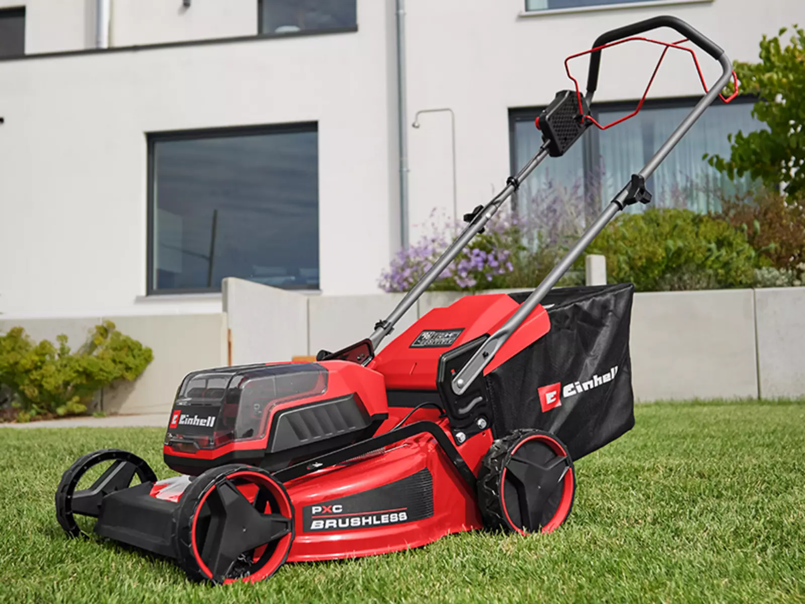 Акумуляторна газонокосарка Einhell GC-CM 36/46 S Li BL (2x 4.0 Ah) готова до використання на газоні перед будинком.
