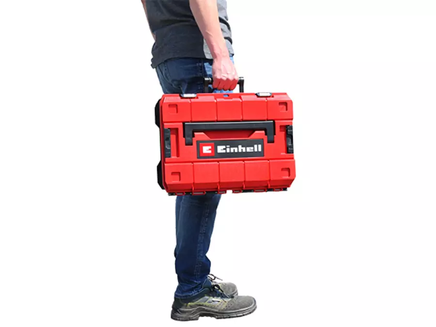 Чоловік несе кейс Einhell E-Case S-F однією рукою – демонстрація навантаження.