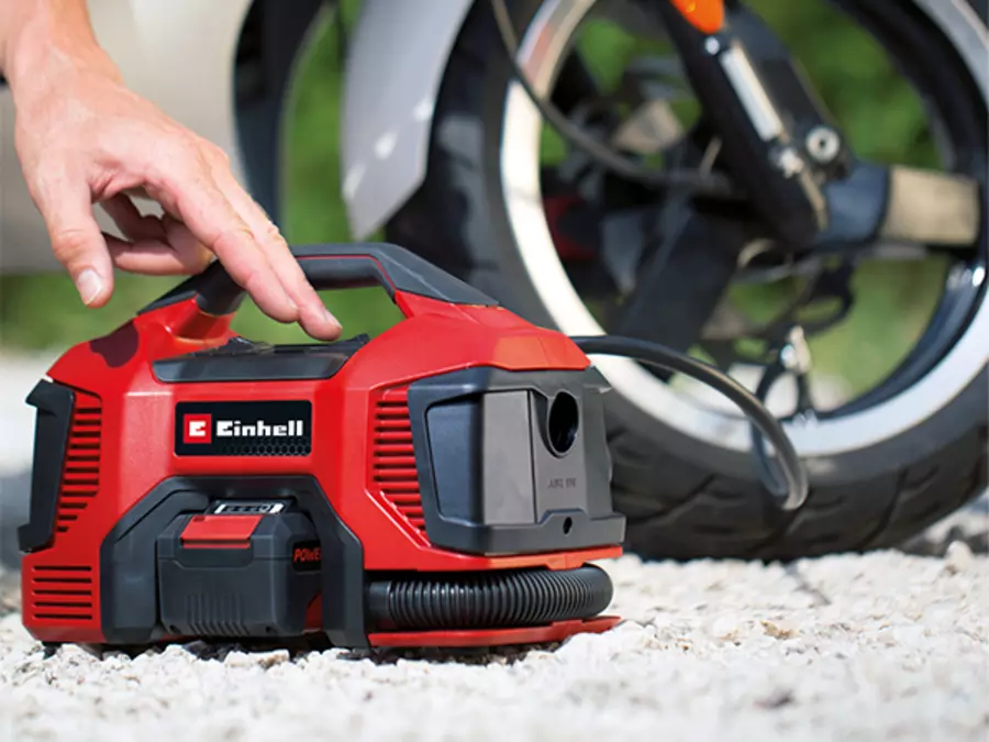 Акумуляторний компресор Einhell TC-AK 18 Li - Solo використовується під час накачування велосипедної шини на відкритому повітрі.
