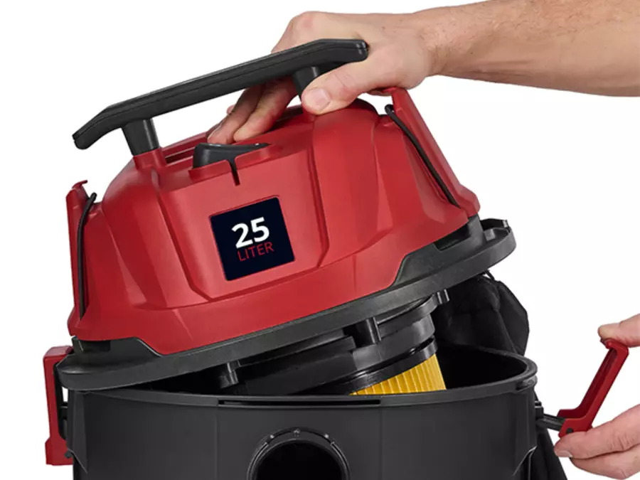 Пользователь открывает пылесос Einhell TC-VC 2555 для влажной и сухой уборки, чтобы опорожнить контейнер для пыли или снять фильтр.